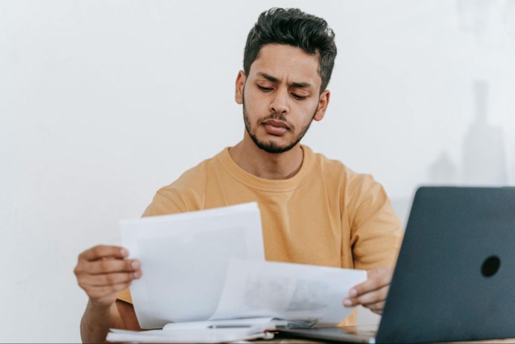 Man looking at the papers he's holding