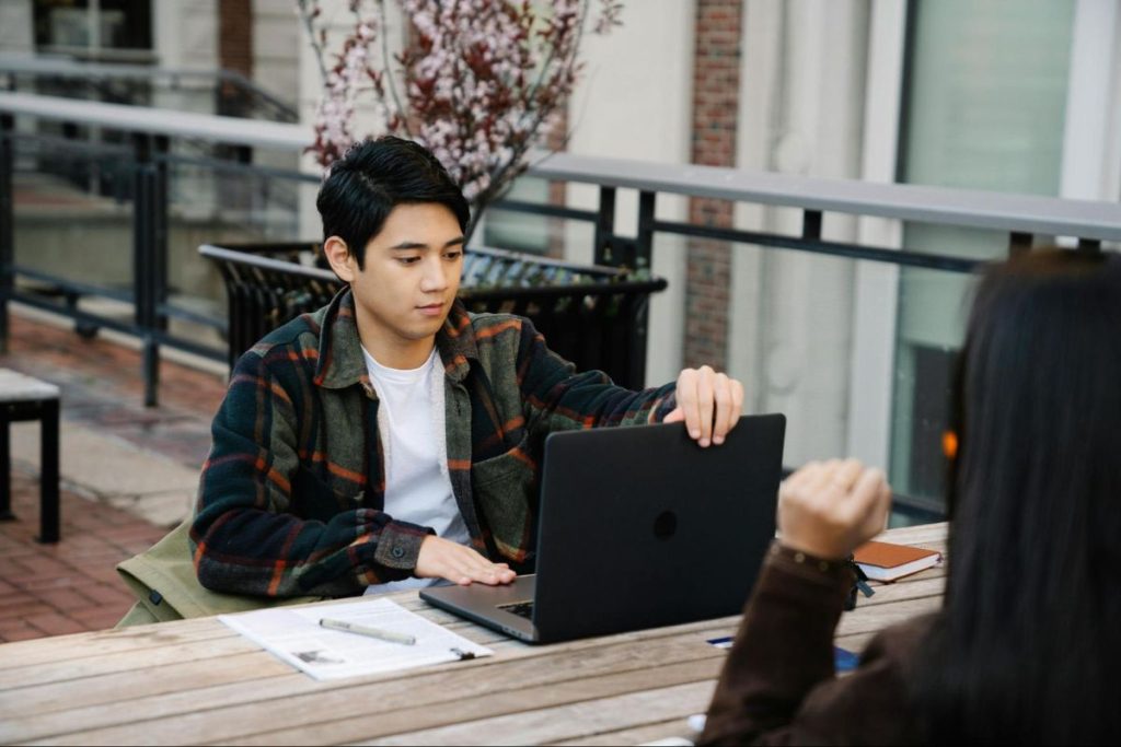 Un homme ouvre son ordinateur portable