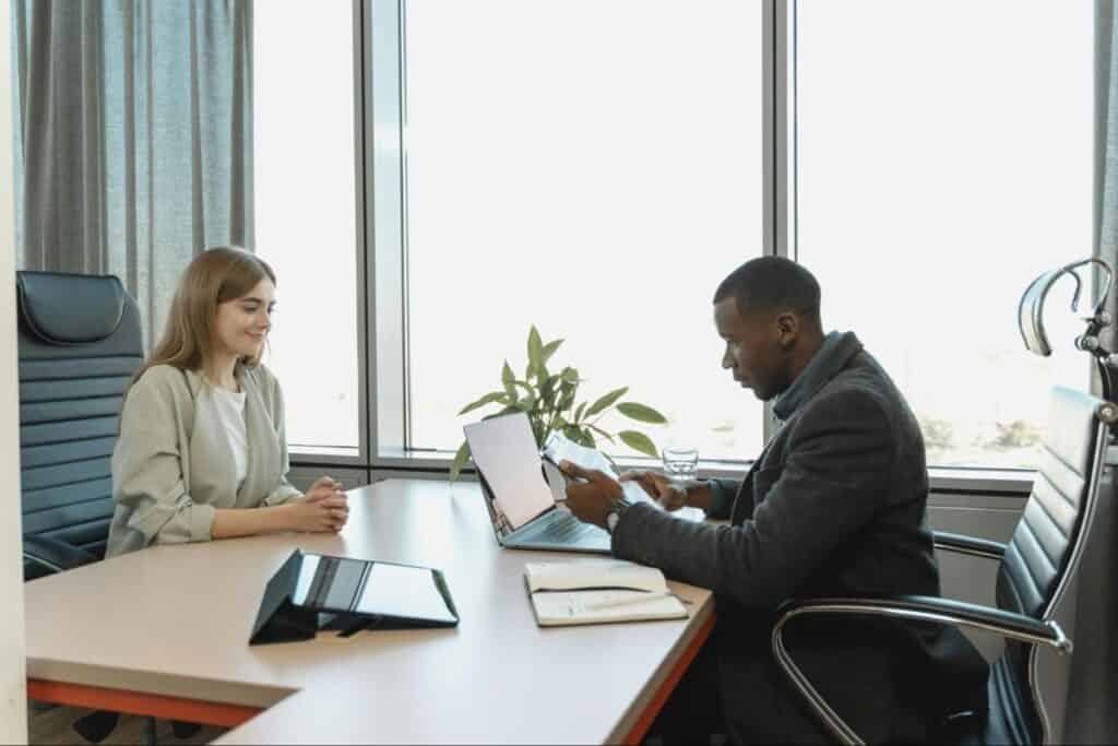 Female applicant and male employer engaged in a job interview, sitting across from each other at a desk