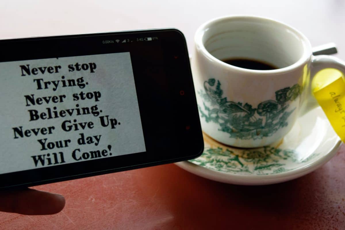 Como aumentar a contagem de palavras: 8 dicas fáceis 5 Cropped image of man holding phone with message by tea