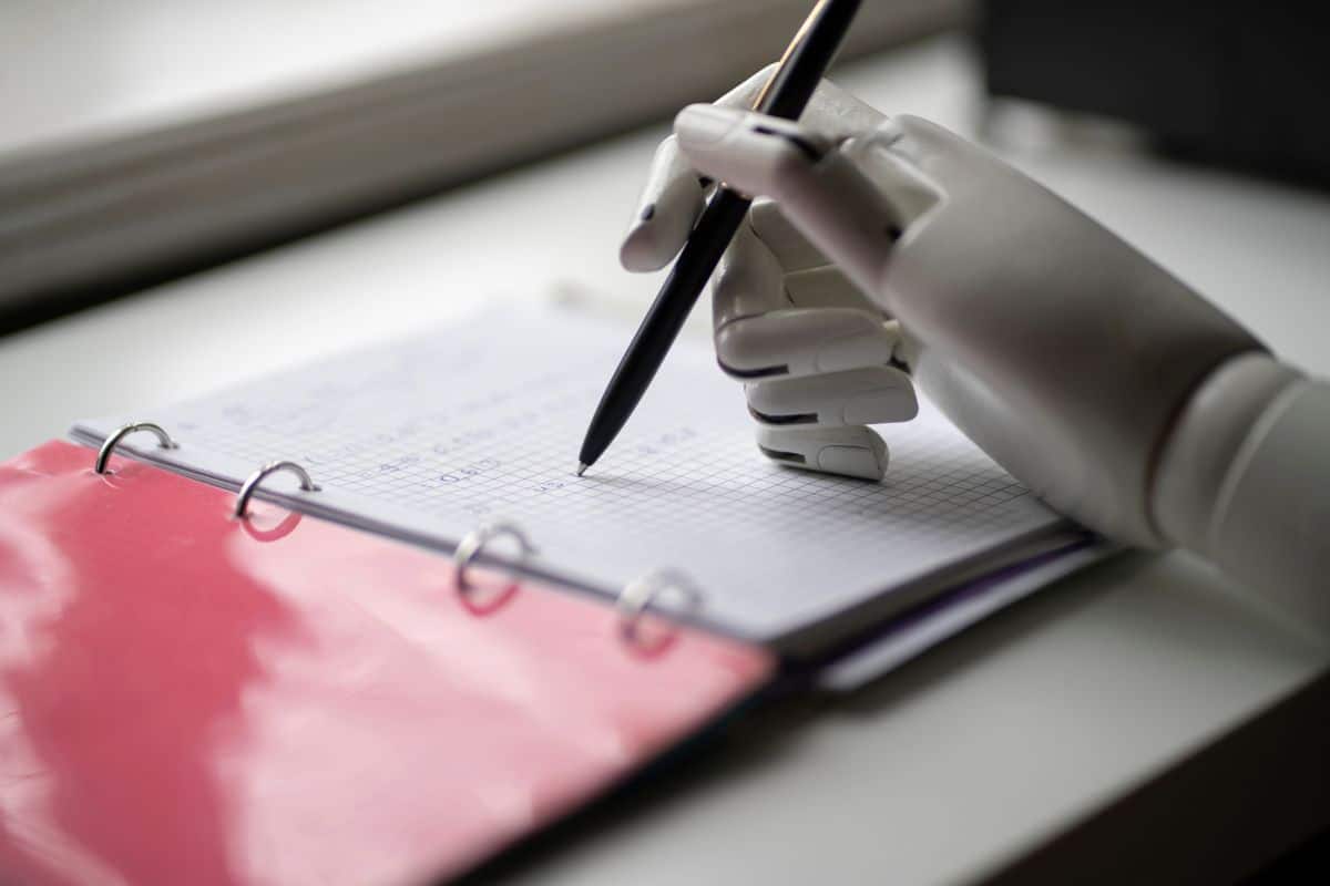 The artificial robotic arm write down some notes with pen