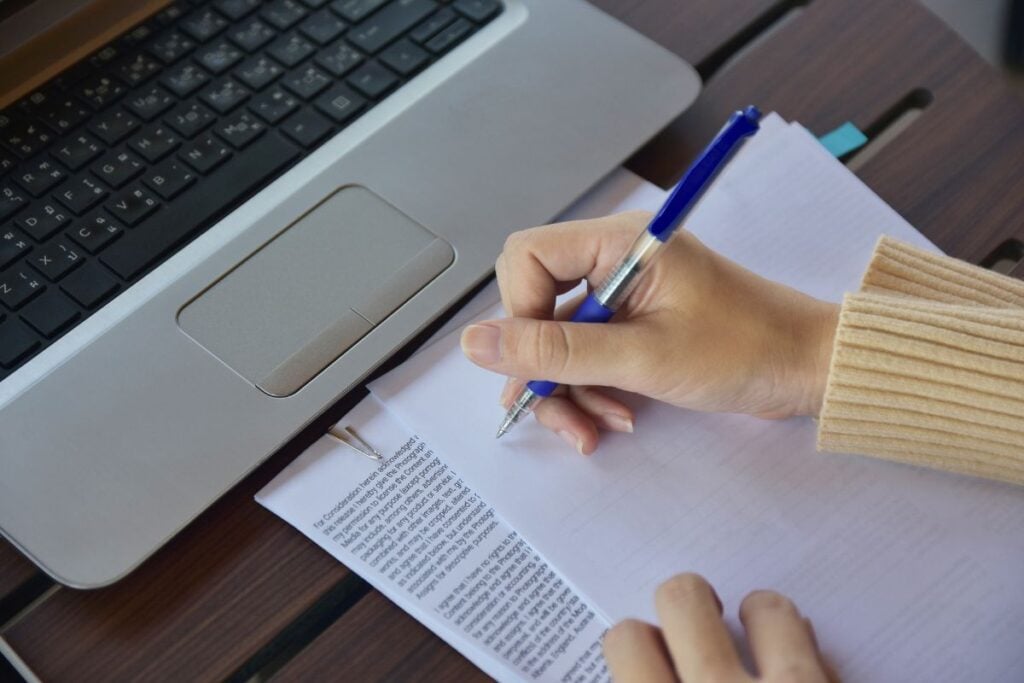 Businesswoman holding pen and writing on paper