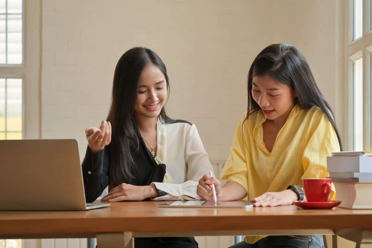 Young woman using phone while sitting on table