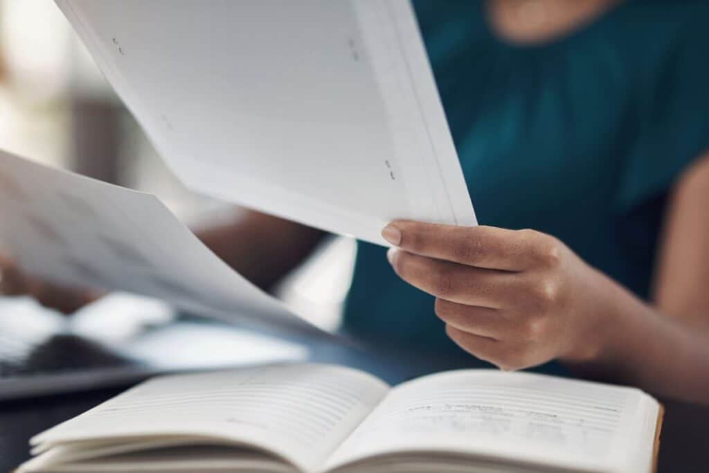Woman hands and review paper in office proofreading and editing pages