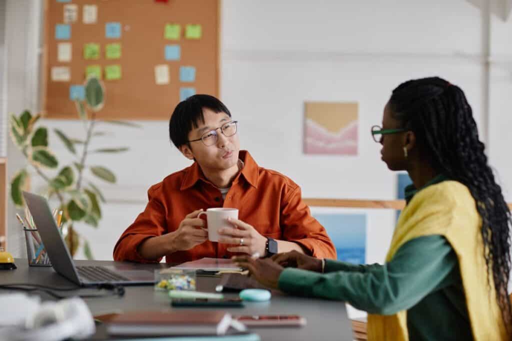 Conversing in modern office setting near a desk