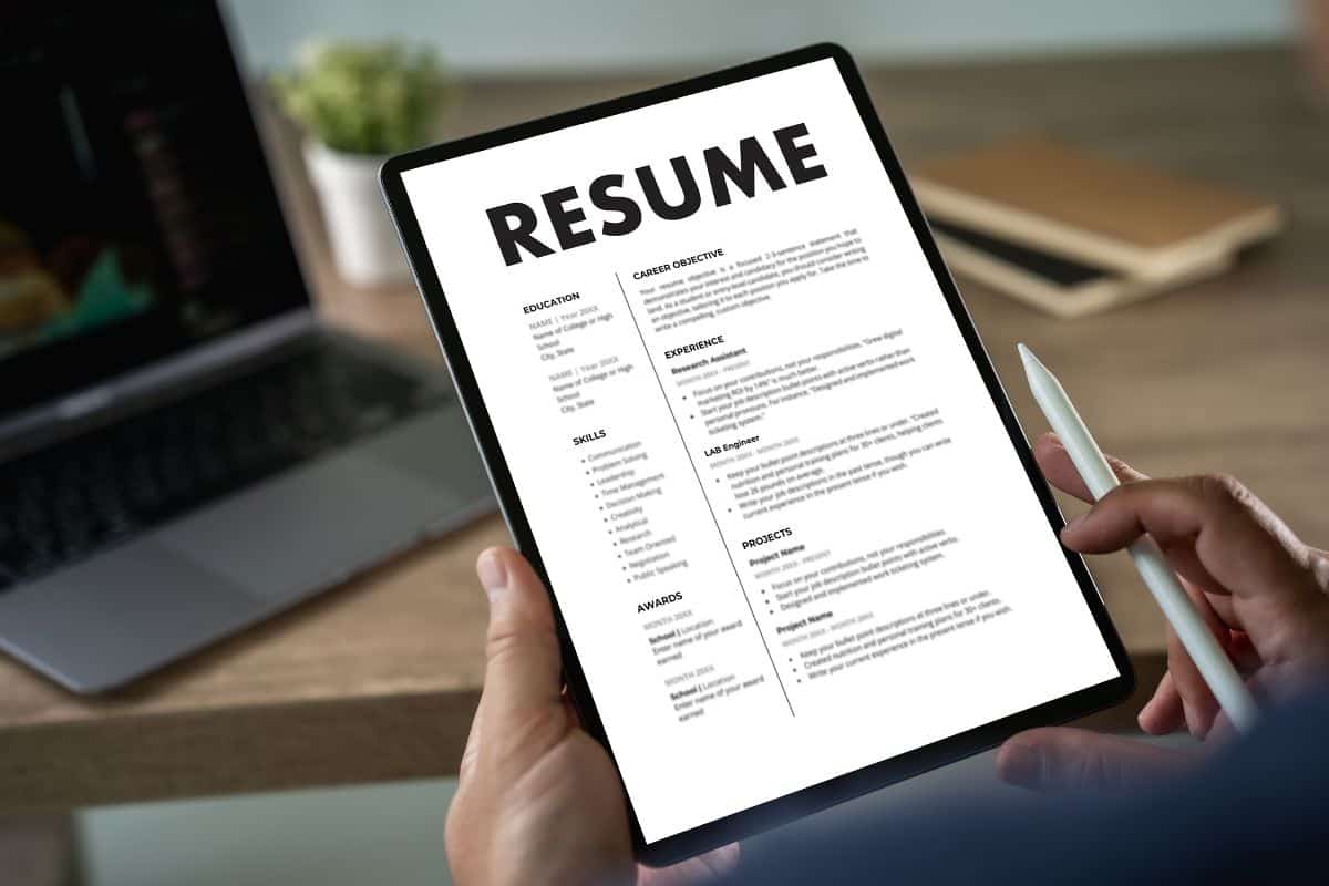 Businessmen reading resumes for a new job use laptops and cvs