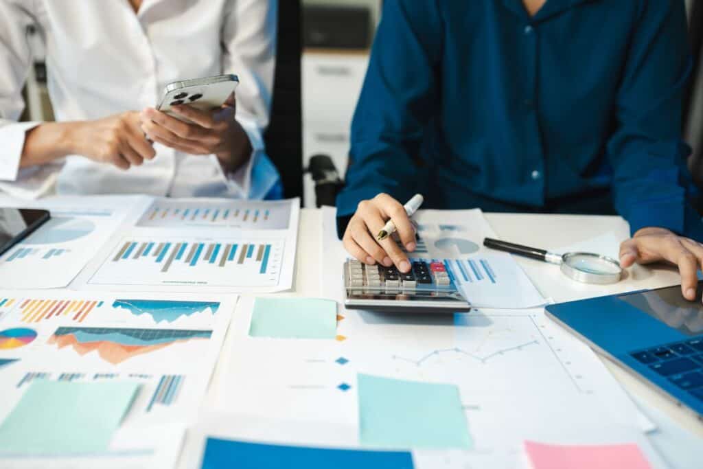 Quantos empregos estão disponíveis em finanças? Lista das melhores carreiras 4 Business team working on desk office with using a calculator to calculate