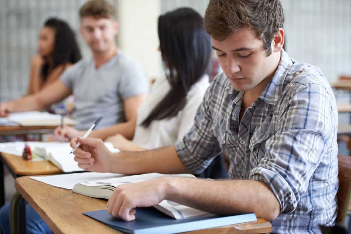 University book and man in class reading with ambition for development