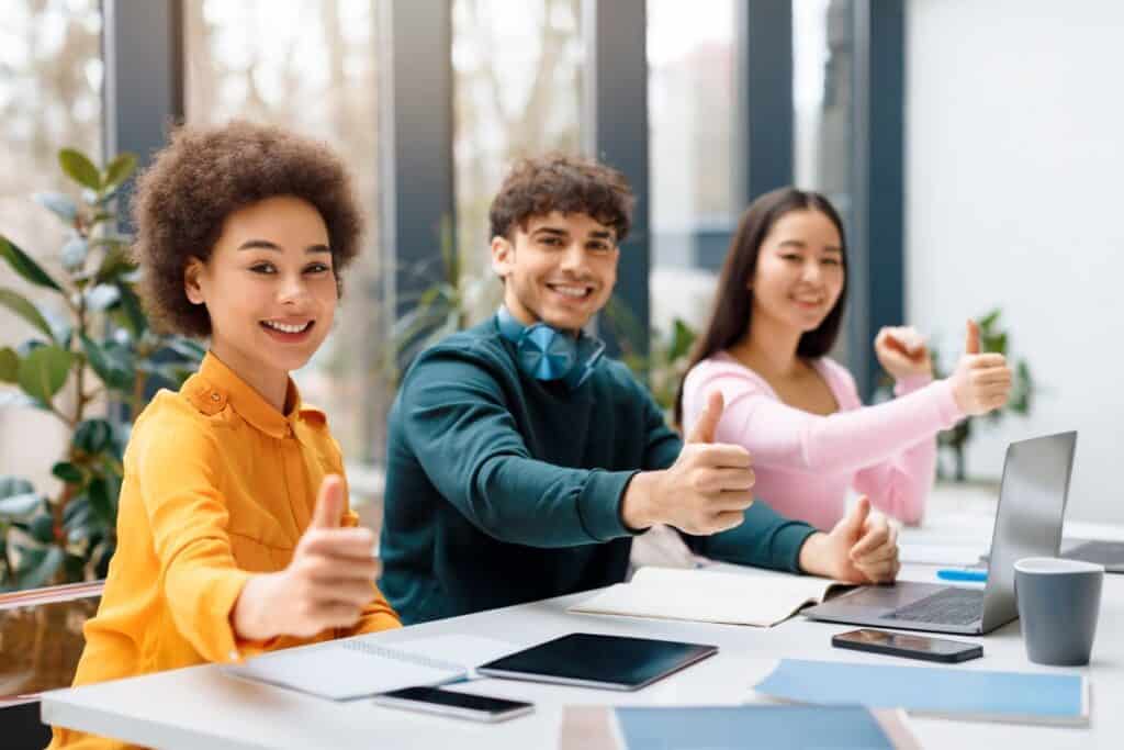 Multicultural students giving thumbs up at study session