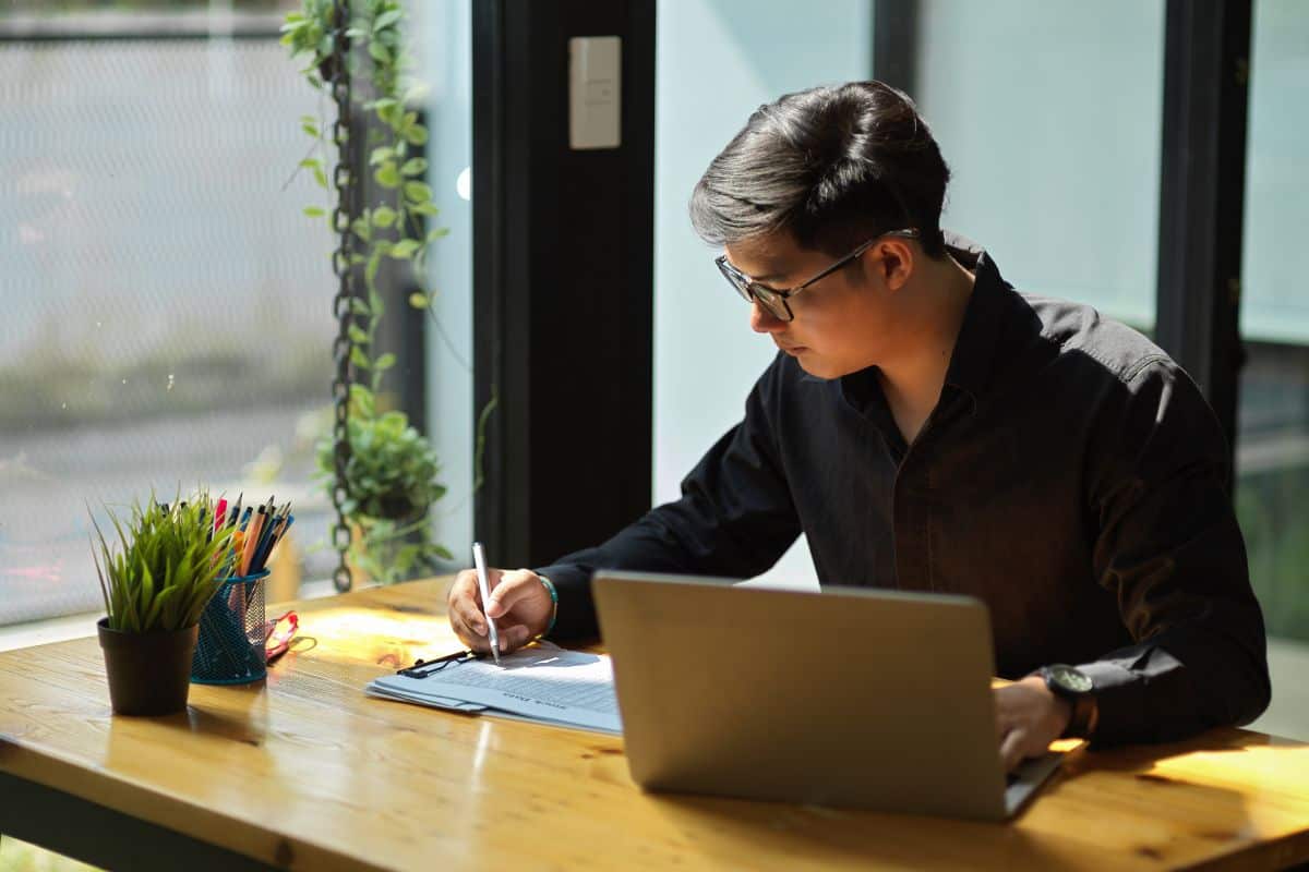 Young man using laptop while sitting on table
