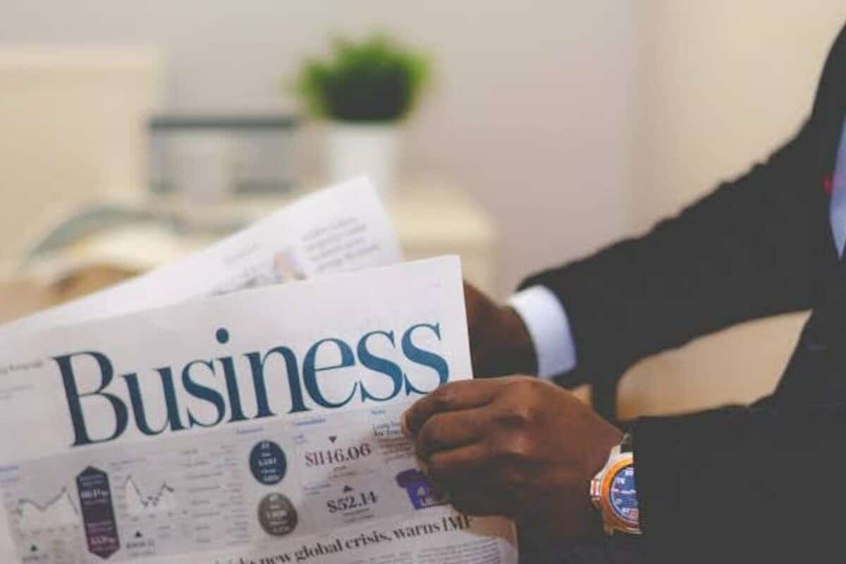 Immagine stock di un uomo d'affari con in mano un giornale