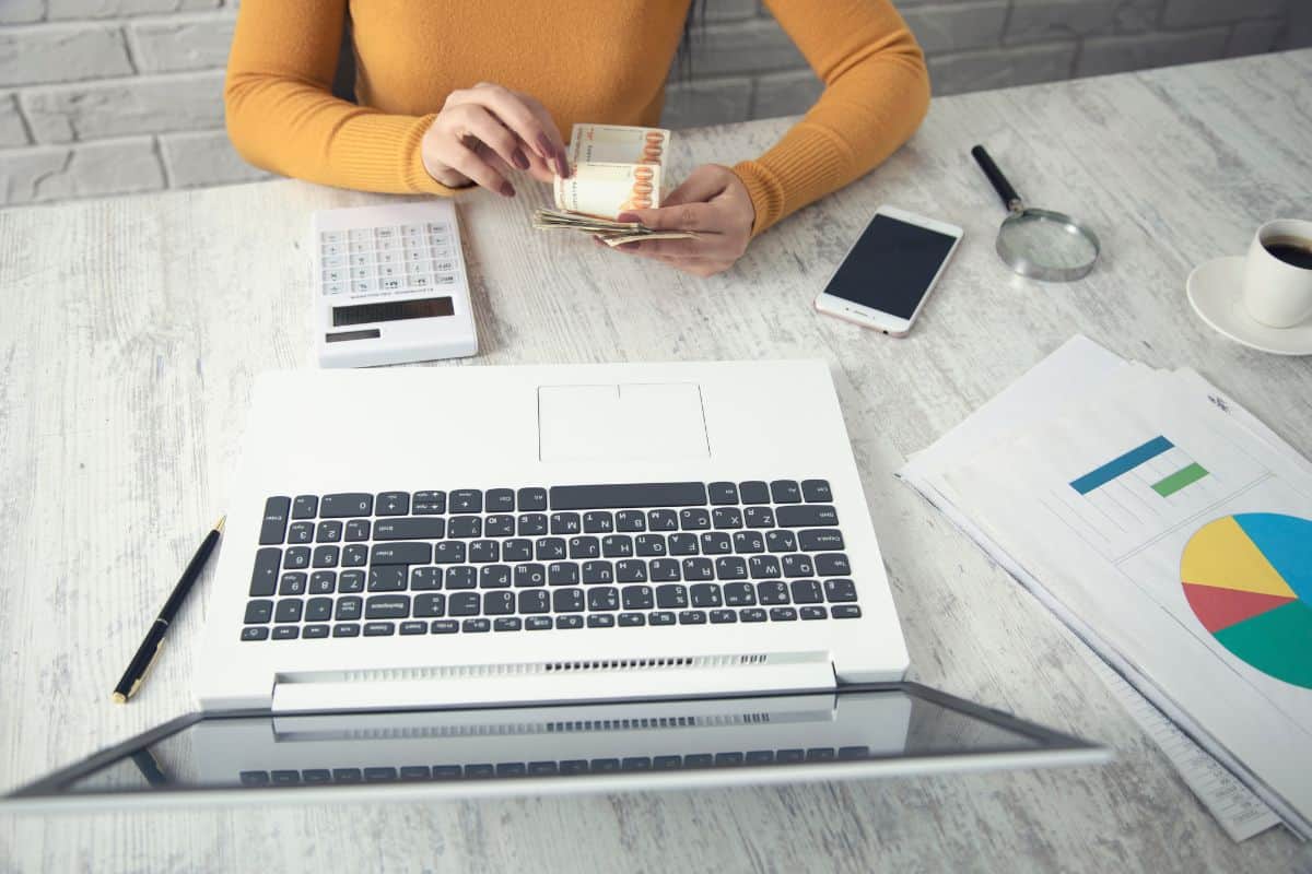 Mujer de negocios con calculadora y dinero en la mano