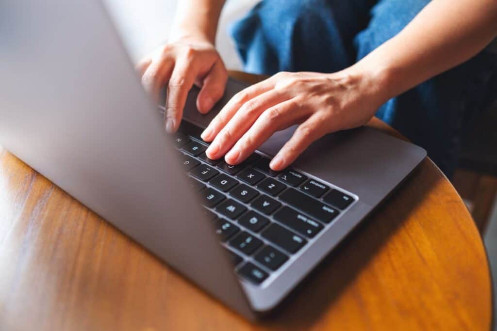Closeup image of a woman working and typing on laptop