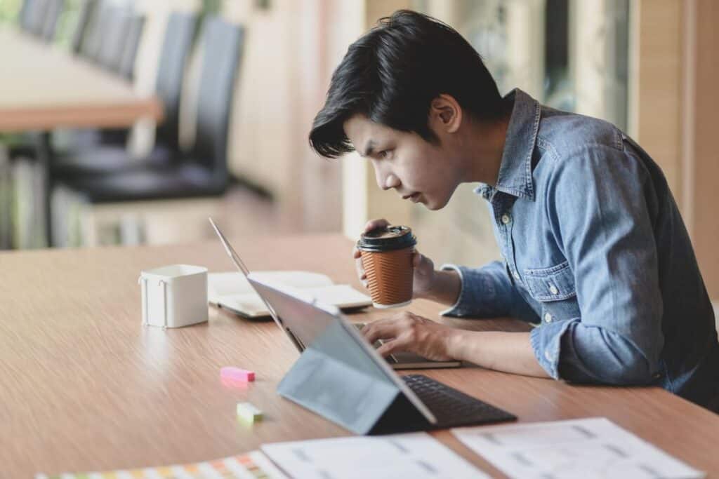 Young woman using mobile phone while sitting on table