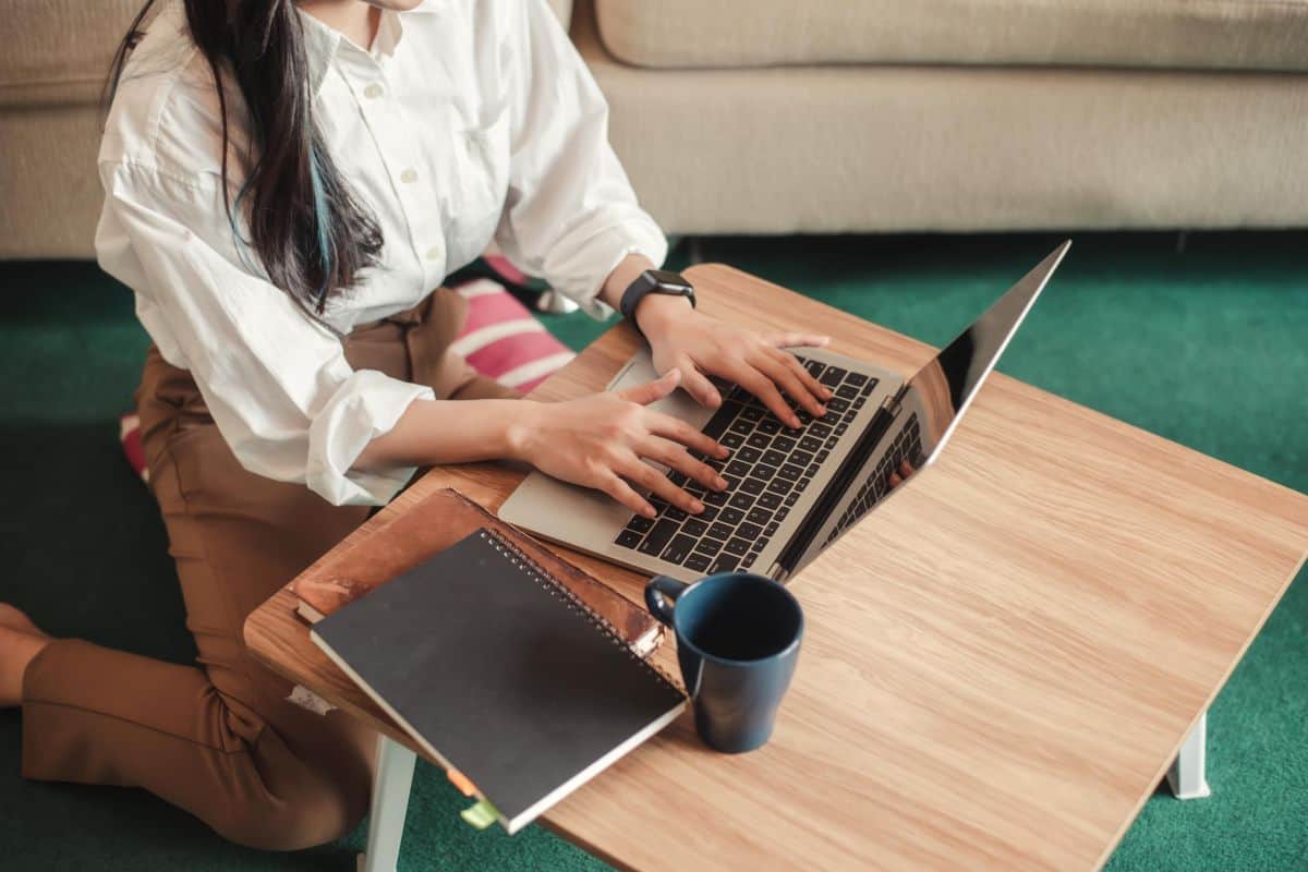 Young woman working with a laptop computer at home top view