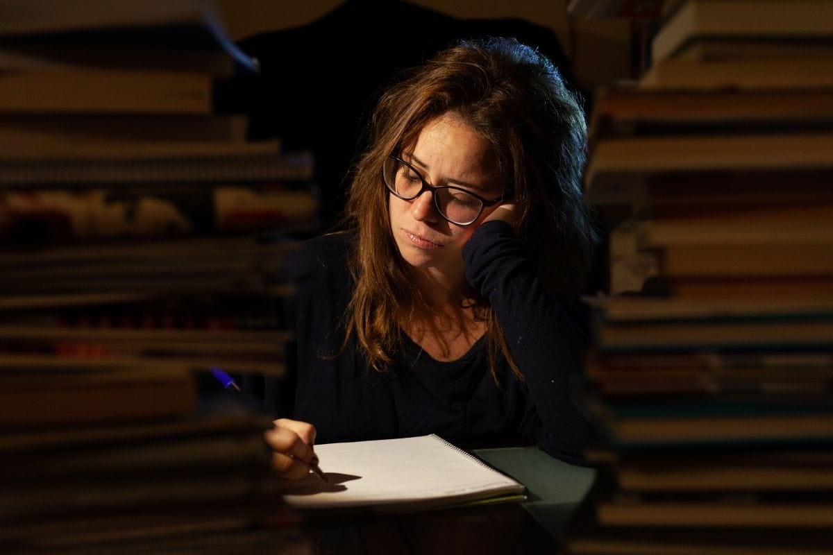 Beautiful woman studies in a library at night