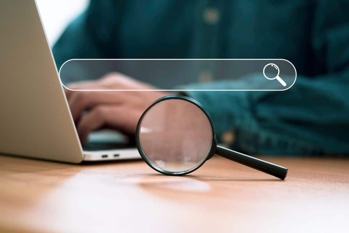 Businessman using computer laptop and magnifier glass