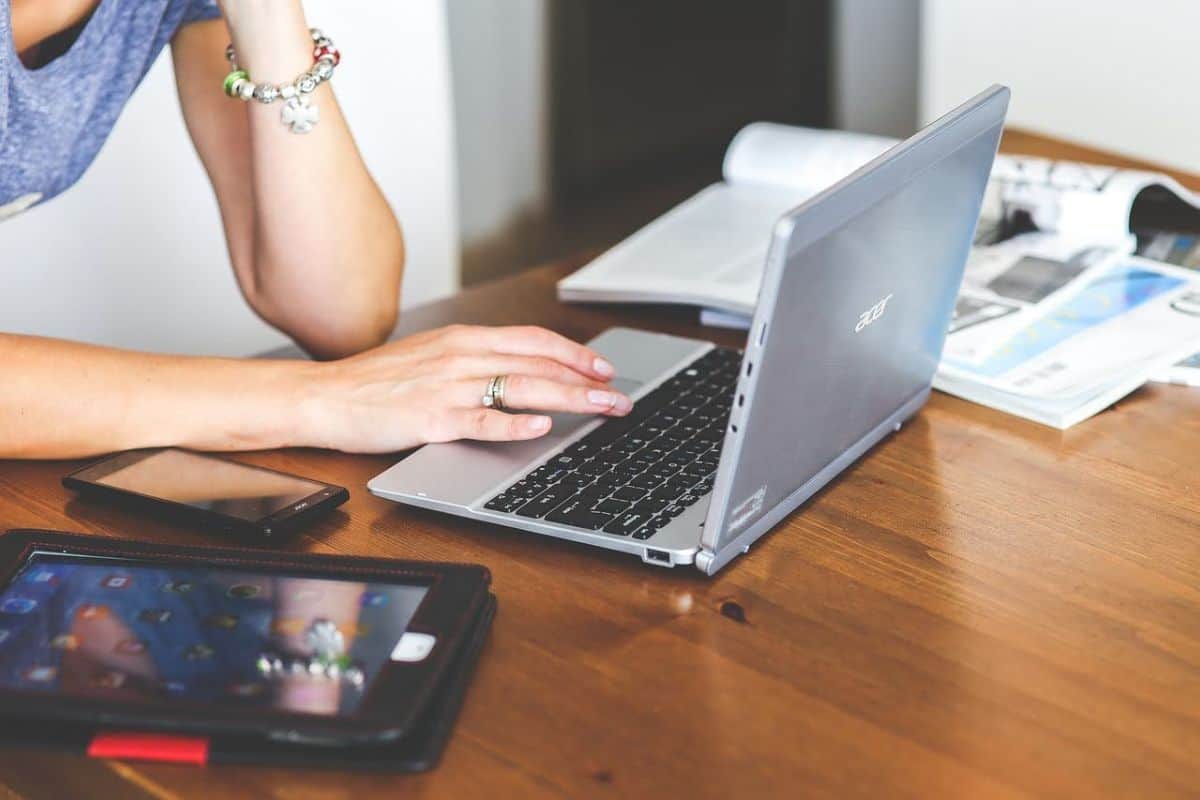 Stock image of a woman scrolling on a laptop while seated at a desk