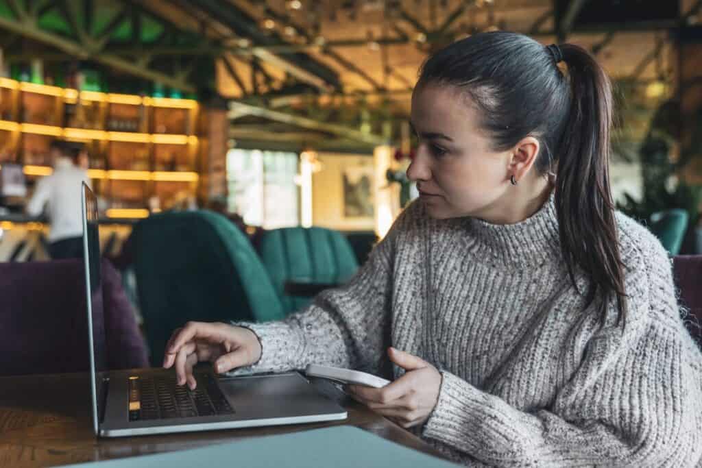 A business woman works in a cafe with a laptop