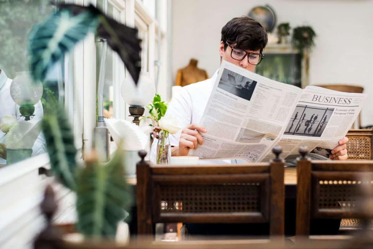 Young man reading newspaper in the morning