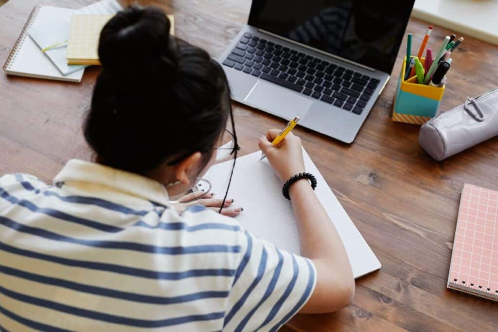 High angle view at teenage girl studying at desk at home