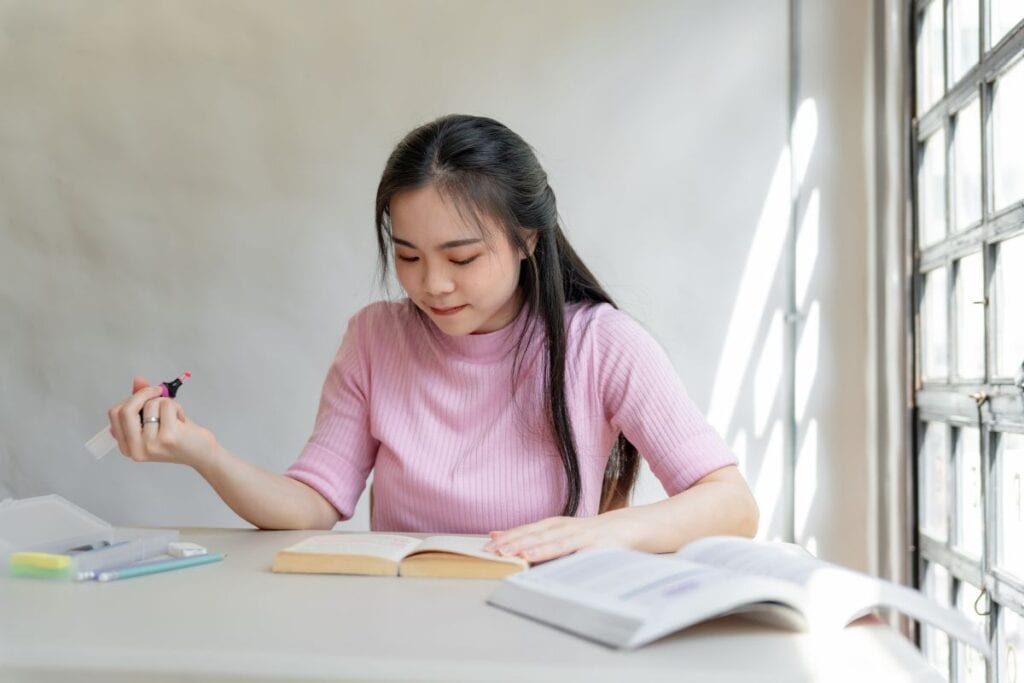 Asian girl student reading book preparing for college exam