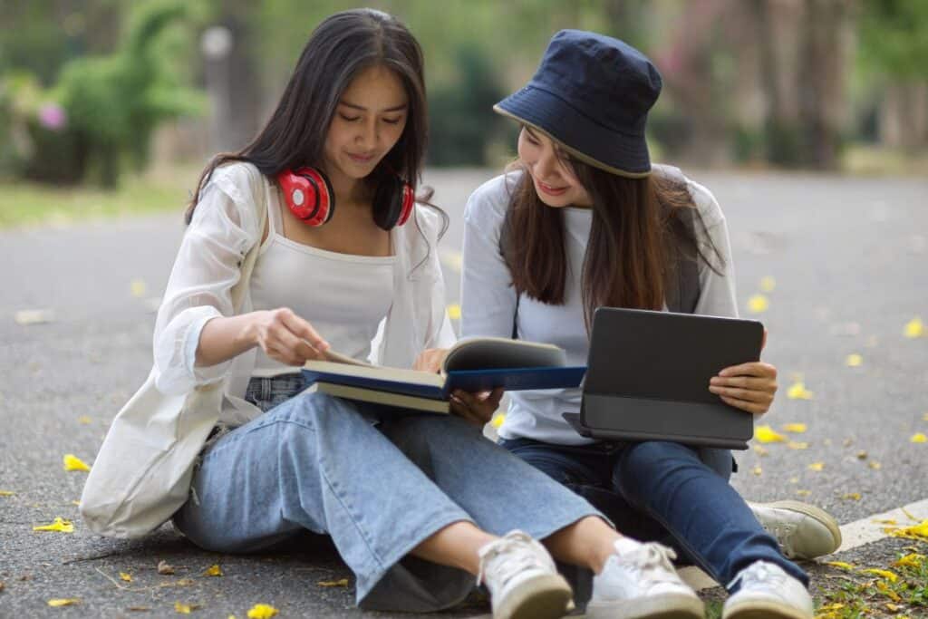 Woman using mobile phone while sitting on street