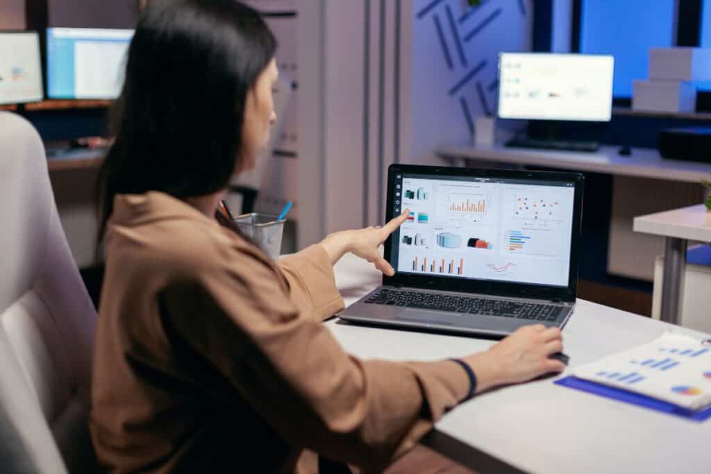 Busy employee pointing at graph working to finish a deadline