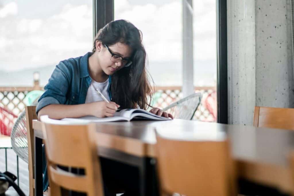Женщина пишет на книге