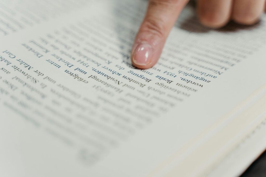 El dedo de una persona señalando el texto de un libro