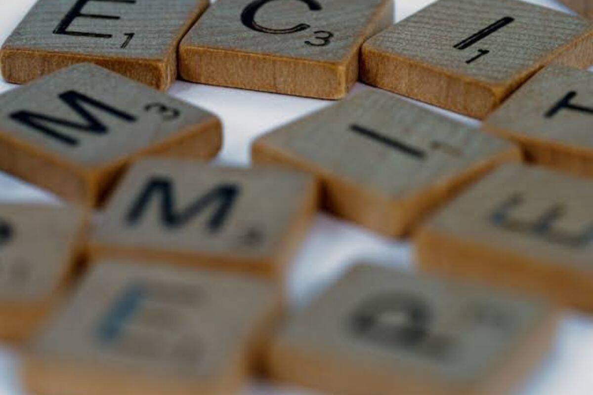 Scrambled wooden letter tiles scattered on a flat surface