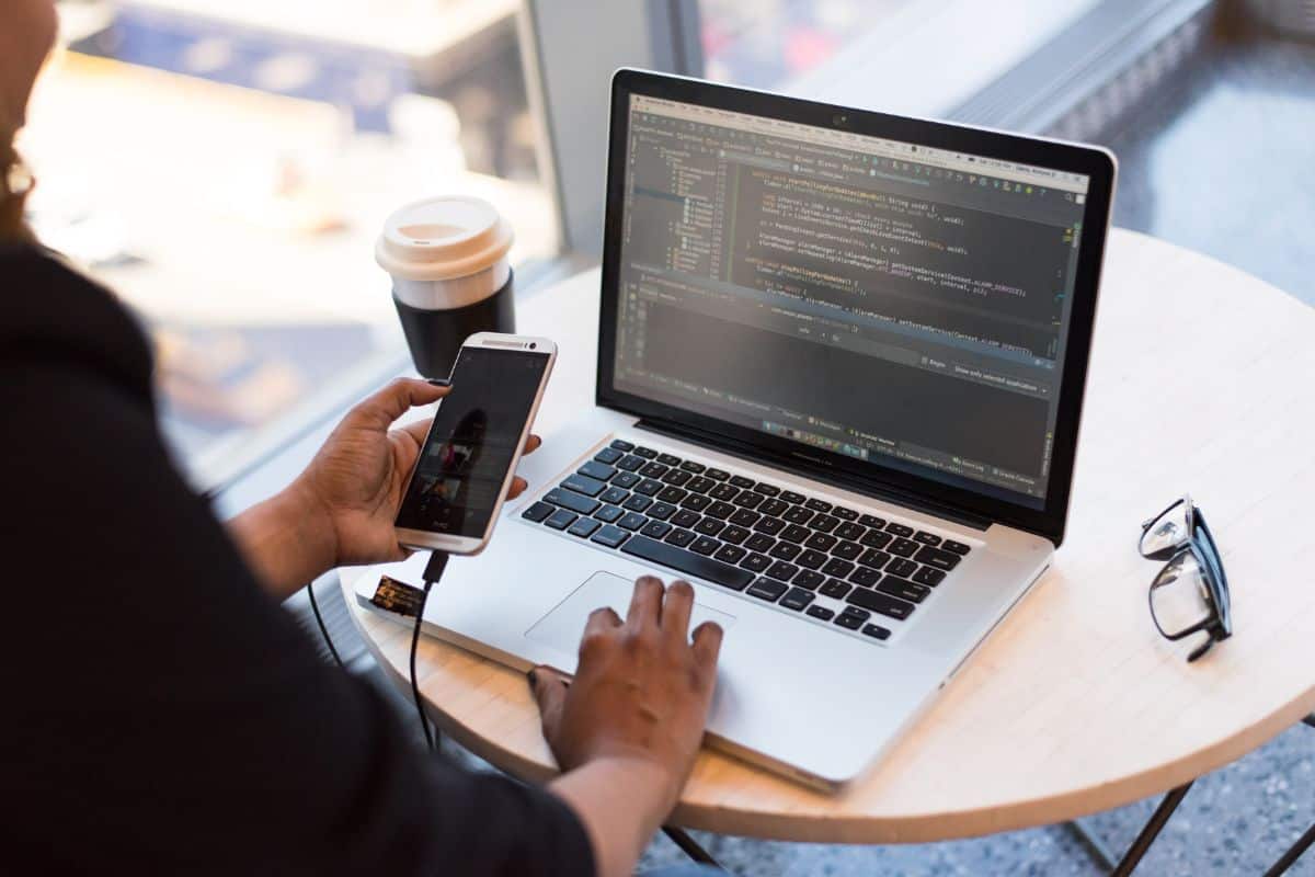 Mulher a trabalhar num computador portátil, possivelmente a programar ou a fazer tarefas de programação