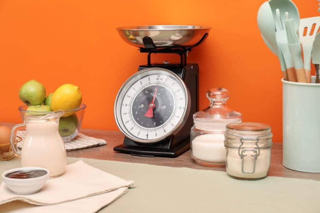 Kitchen scale products and cooking utensils on wooden table