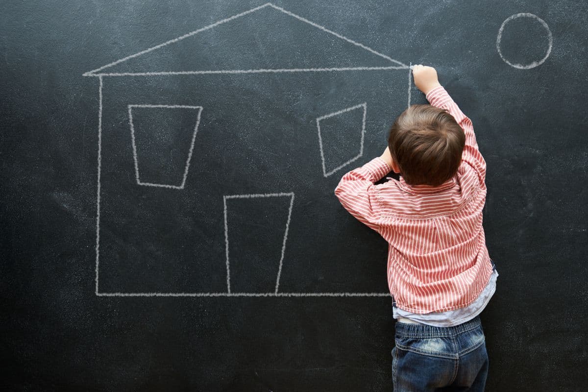 Kid drawing and art of house on chalkboard of preschool