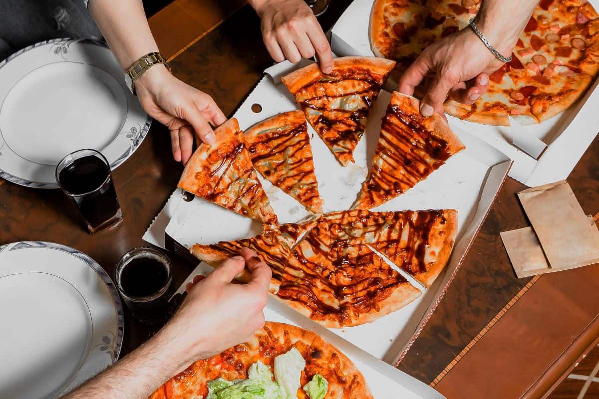 Company of friends eating pizza and talking