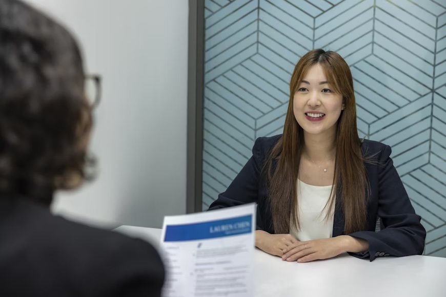 종이 한 장을 앞에 두고 테이블에 앉아 있는 여성