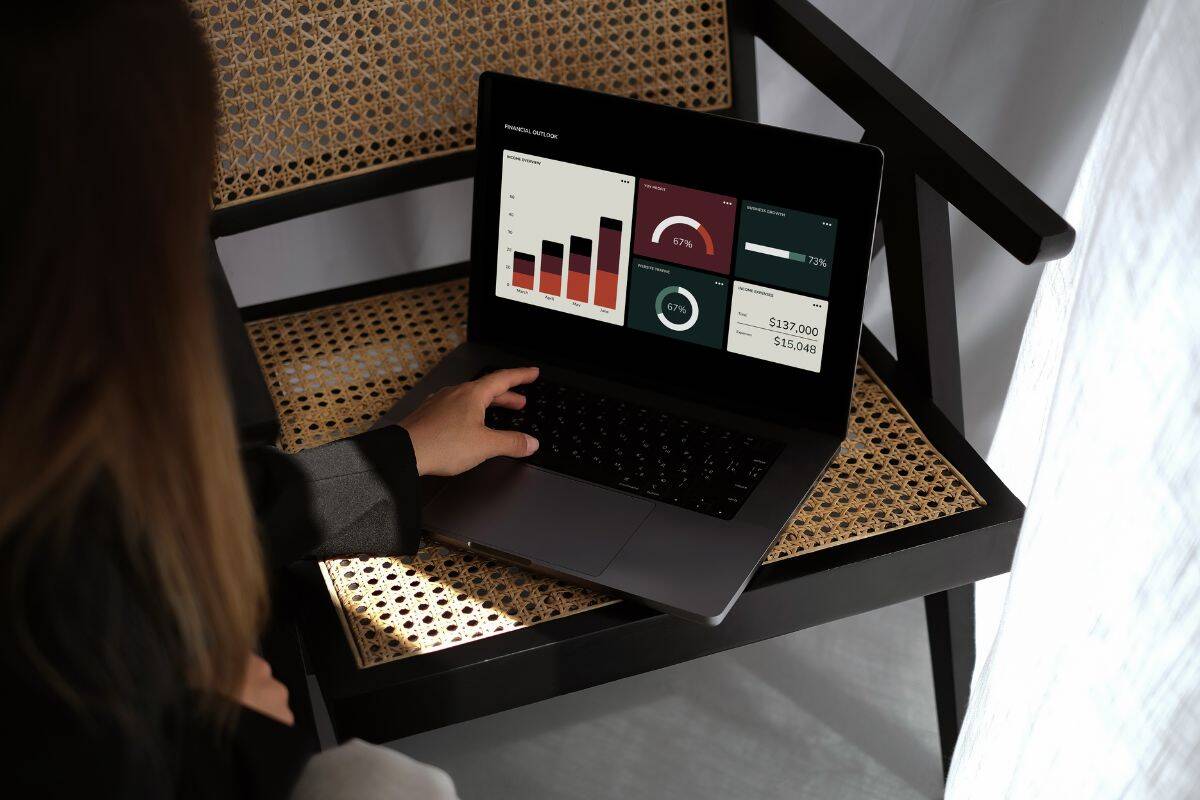 Woman using a laptop displaying data analytics on screen