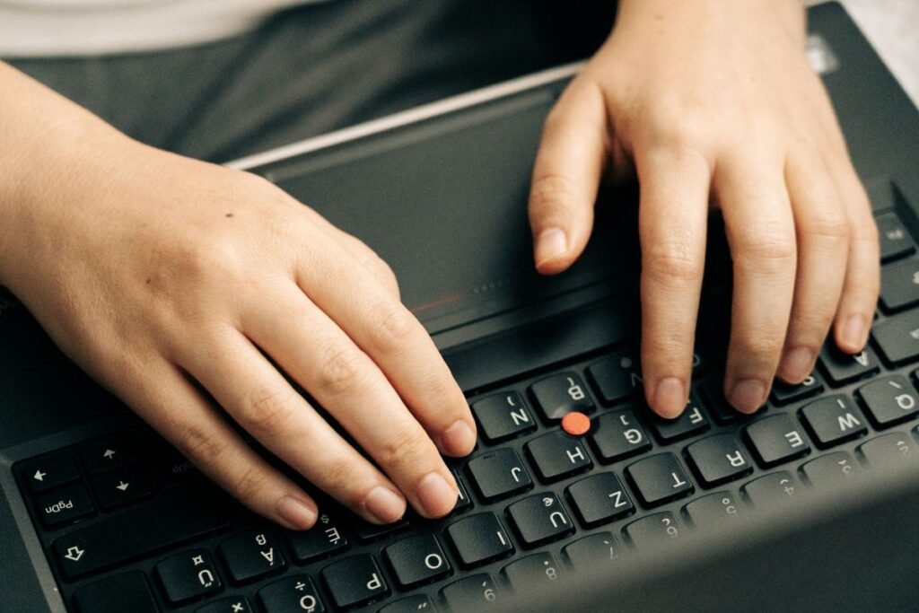 Persons hånd på sort computertastatur