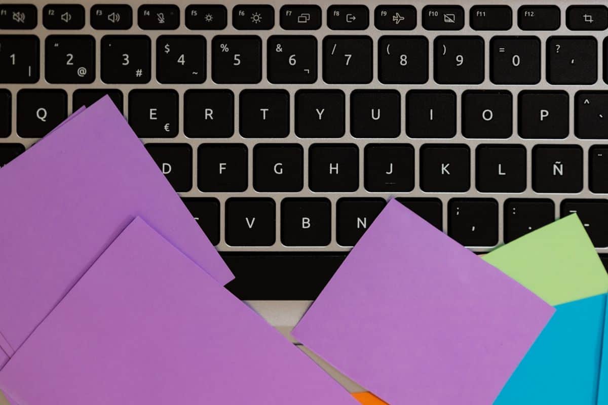 Close up of keyboard with multicolored sticky notes on it