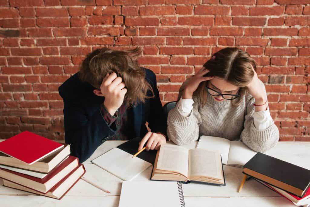 Pair of tired students preparing for exams