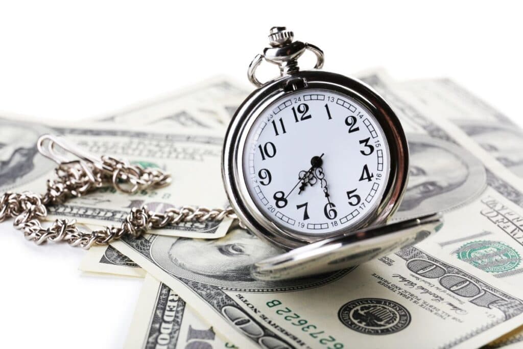 
Silver pocket clock and money closeup time is money concept
