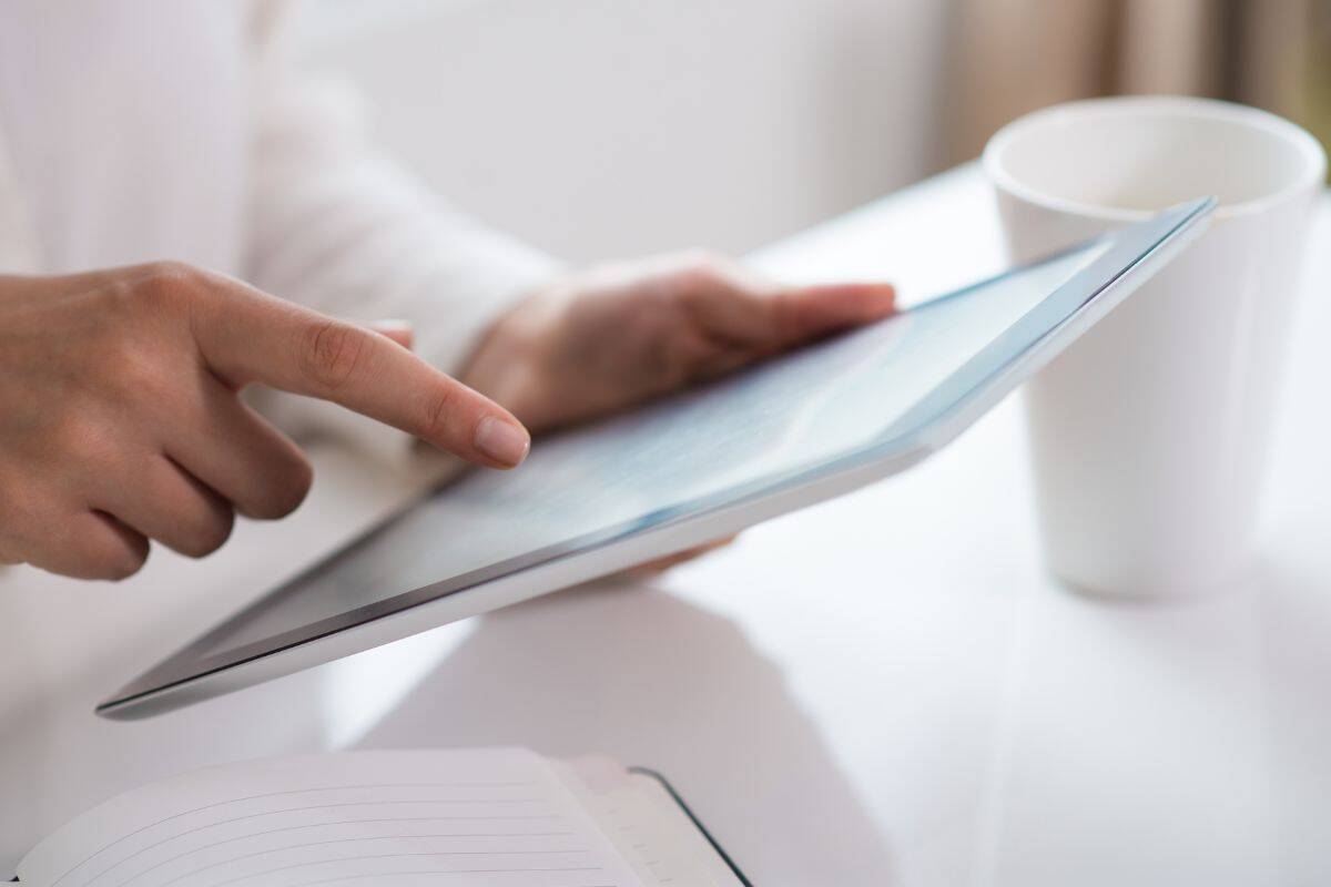 Nærbillede af kvindehånd, der bruger digital tablet ved tablet