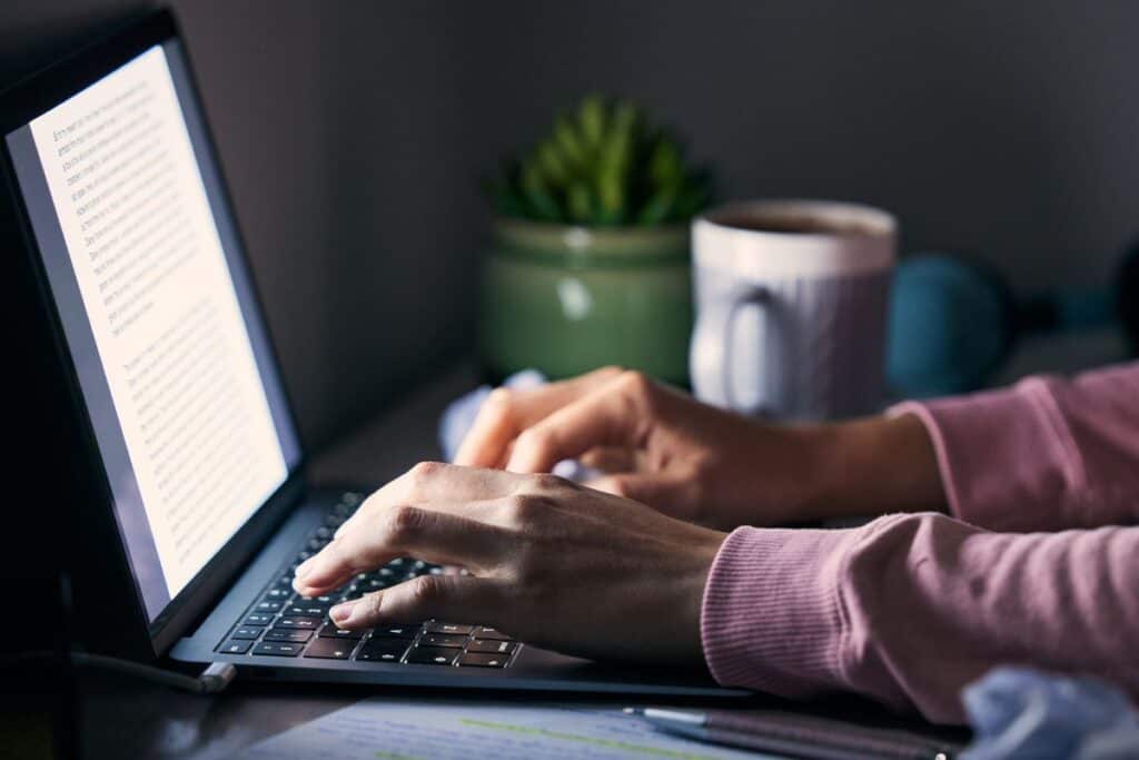Hands laptop and writing in office at night journalism