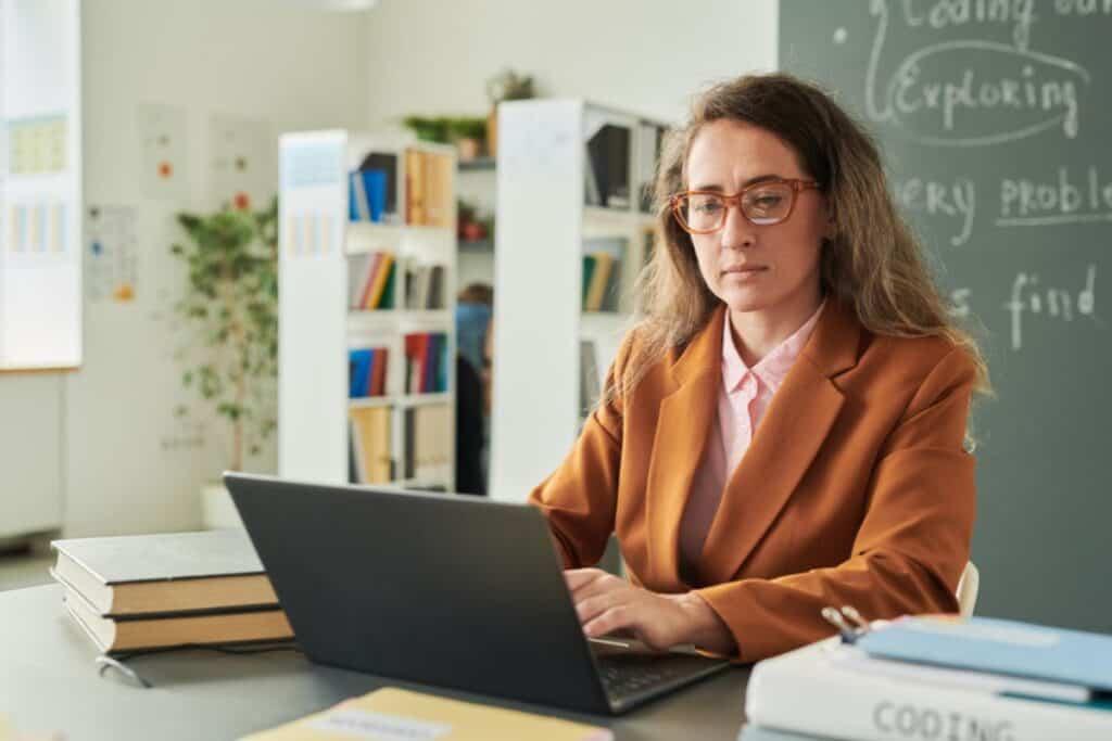 What AI Checker Do Teachers Use in 2026? 5 Teacher using laptop at desk