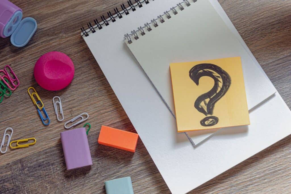 Creative desktop question mark in notepad paper clips