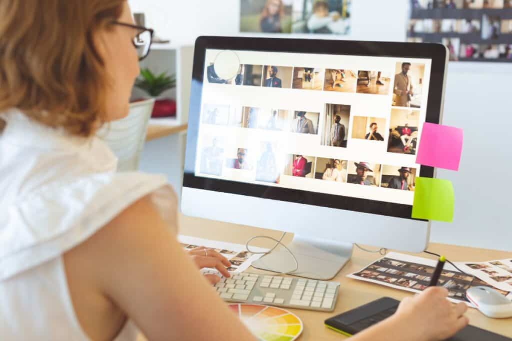 Female graphic designer working on graphic tablet at desk in office