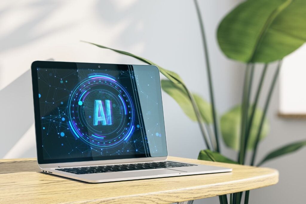 Close up of laptop on wooden desk with decorative plant