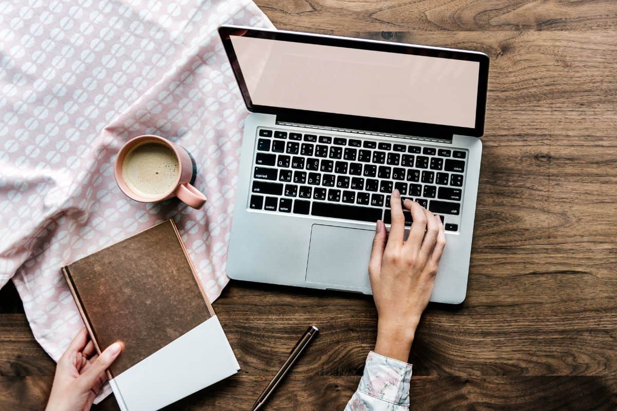 Letecký pohled na ženu používající notebook na dřevěném stole