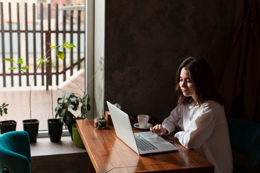 Woman in coffee shop working on laptop