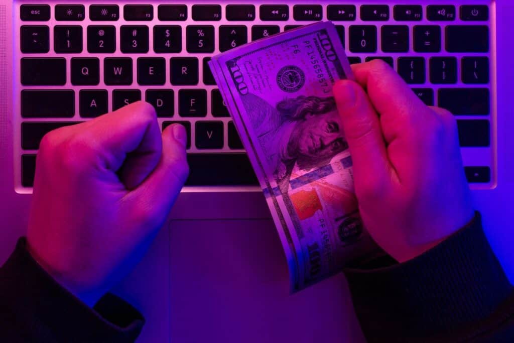Money in male hands on the background of a laptop